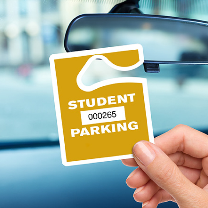 Student permit on rearview mirror at school parking lot.